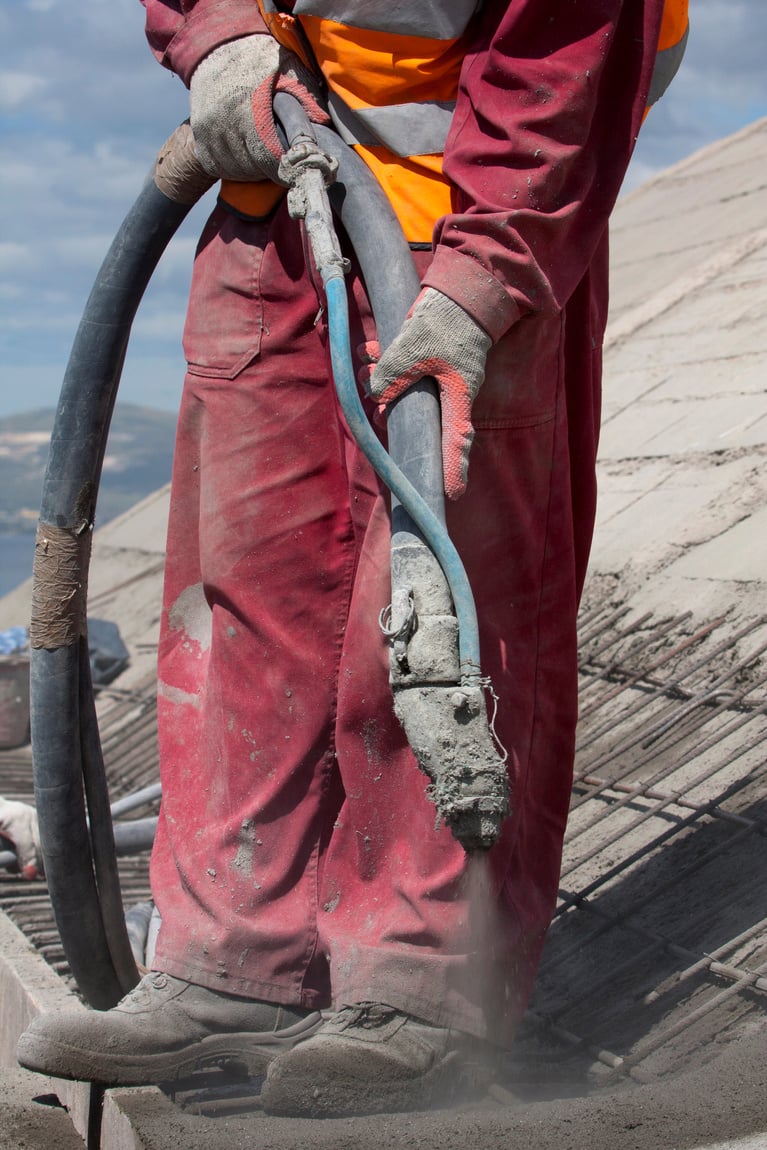 Worker on top of hale is spraying concrete